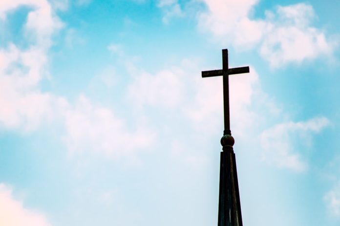 church tower with cross against a blue sky