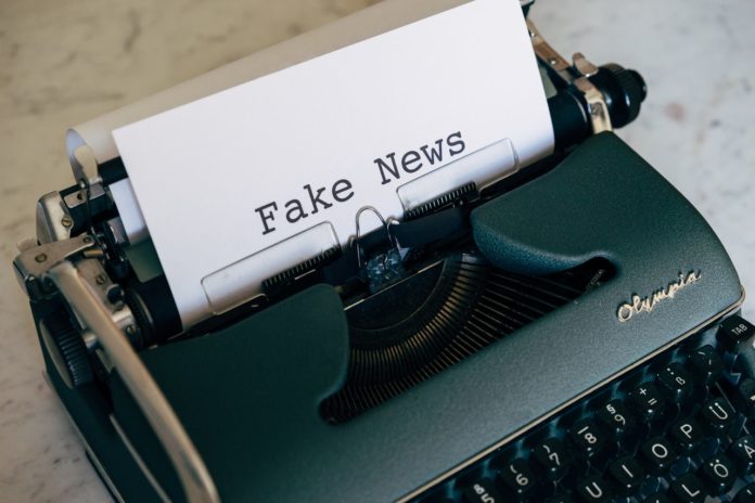 typewriter with fake news written on paper