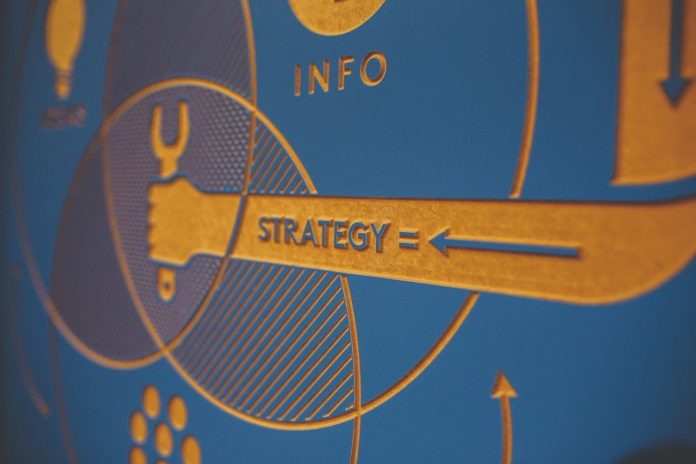 close up photo focusing on the word strategy on engraved sign with infographic